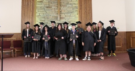 group of adult graduates in caps and gowns